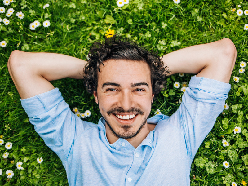 man laying in grass smiling