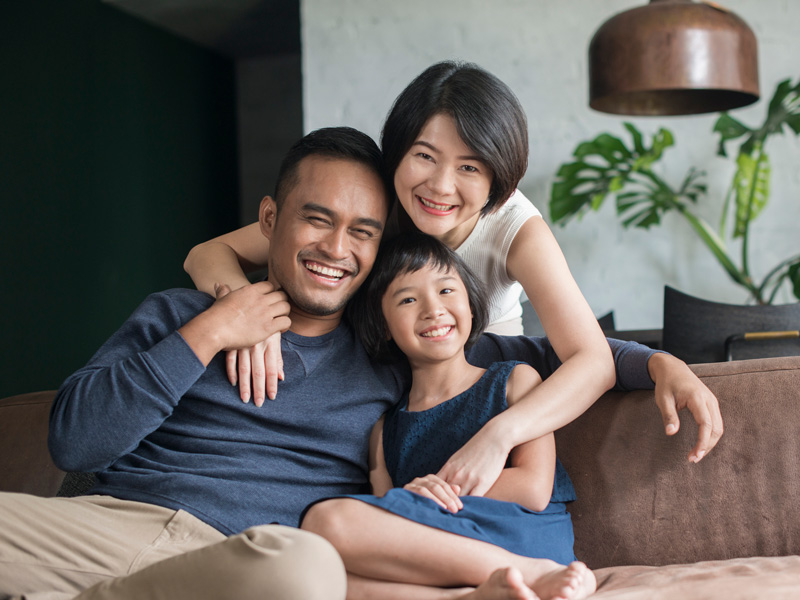 family sitting on couch smiling