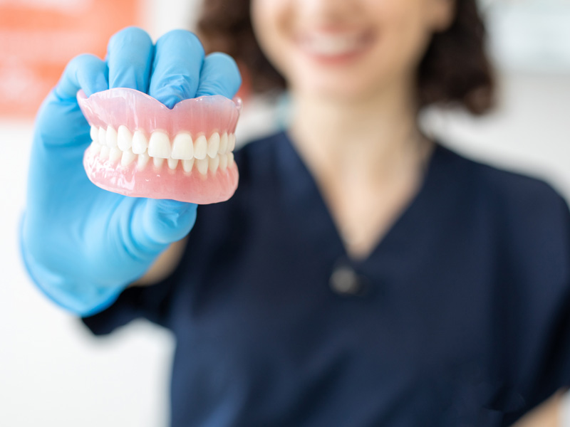 dentist holding dentures
