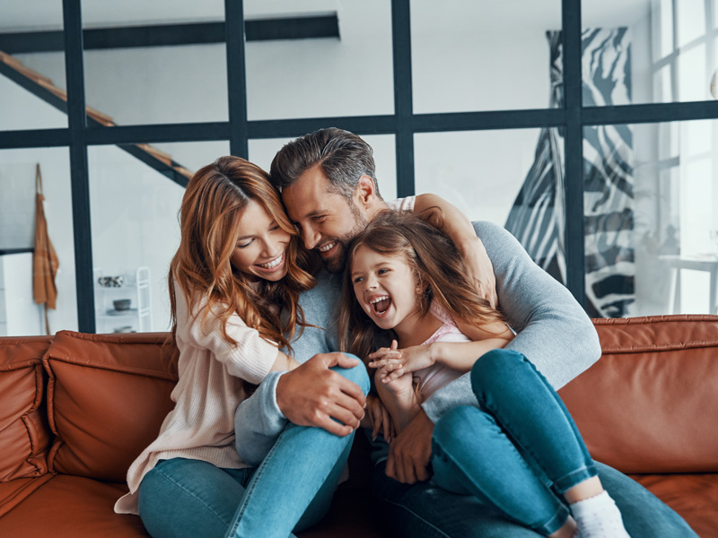 family smiling on a couch