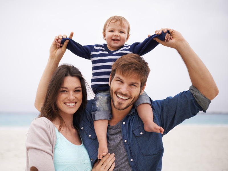 family smiling on a beach