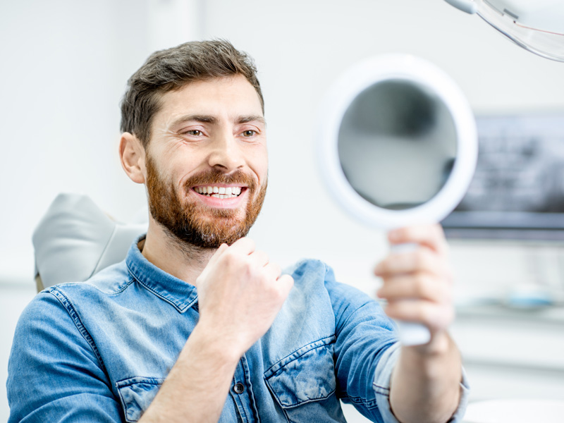 man holding a mirror and smiling