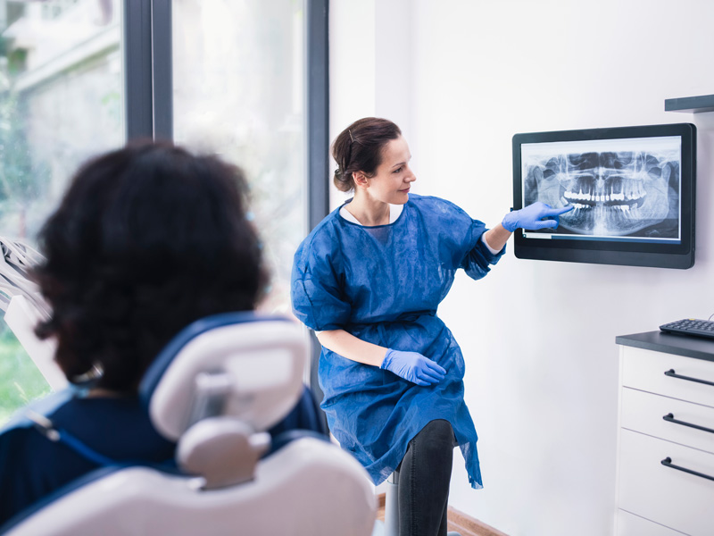 dentist showing patient xrays of teeth