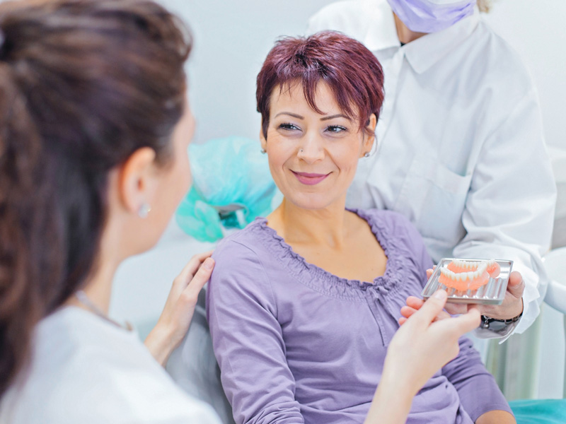 patient in dental chair smiling at dentist